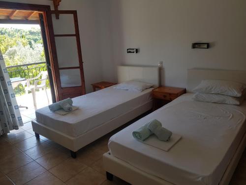 two beds in a room with a balcony at Kaiti Studios 1 in Koukounaries