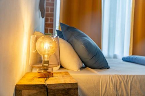 a lamp on a table next to a bed with pillows at Casa Mara Dakar in Dakar