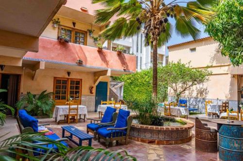 達喀爾的住宿－卡薩瑪拉達喀爾酒店，一座配有蓝色桌椅的庭院和一座建筑