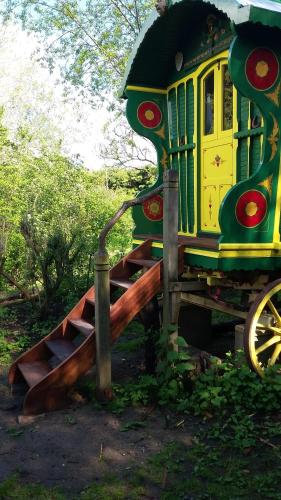 a green and yellow train engine sitting on display at Gypsy Caravan at Alde Garden in Saxmundham