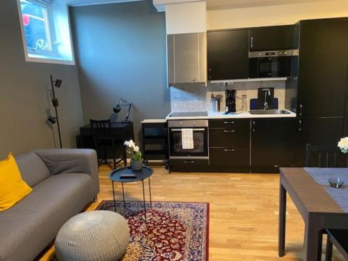 a living room with a couch and a kitchen at Magnolia House Norrviken in Sollentuna