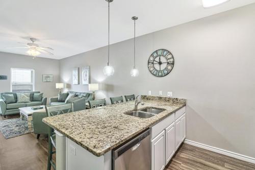 a kitchen with a sink and a living room at Chillin' Channelside in Padre Island