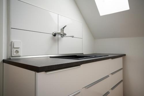 een keuken met witte kasten en een spoelbak bij Top Old Town Apartment 2 baths in Düsseldorf