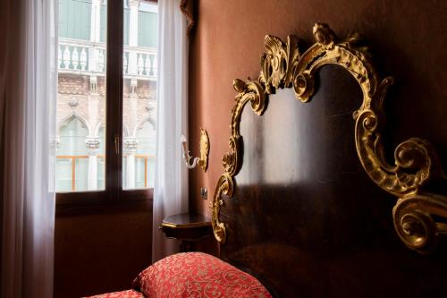 a bed with a mirror next to a window at Hotel Ateneo in Venice