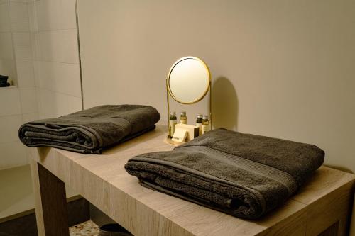 zwei braune Handtücher auf einer Theke mit einem Spiegel in der Unterkunft MammaDada charm rooms in Bari