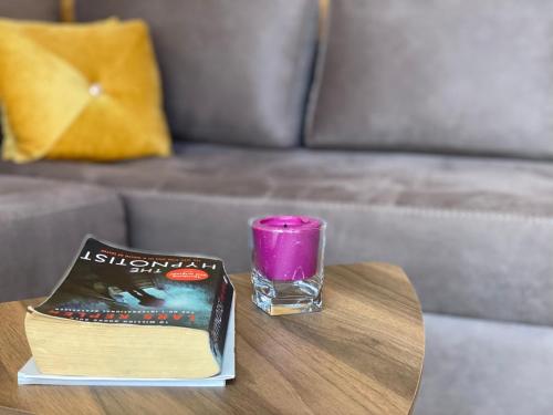 a book and a candle on a table at Agora Farmhouse in Koman