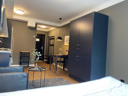 a bedroom with a blue cabinet and a living room at Magnolia House Norrviken in Sollentuna