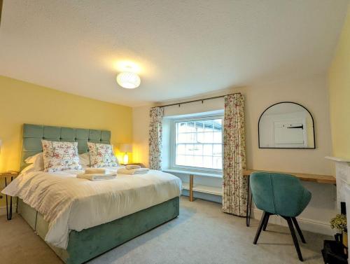 1 dormitorio con cama, ventana y silla en Skelwith Fold Cottage No.3 en Elterwater