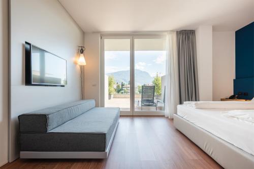 a hotel room with a bed and a large window at HOODY ACTIVE & HAPPINESS HOTEL in Arco