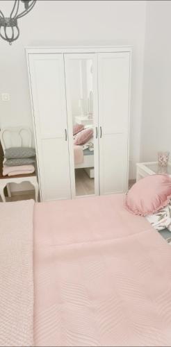 a white bedroom with a bed and a mirror at Pod Świerkami in Myślibórz