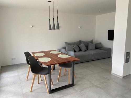 ein Esszimmer mit Tisch und Stühlen und einer Couch in der Unterkunft Strandnah und ruhig mit Tiefgaragenstellplatz in Sierksdorf