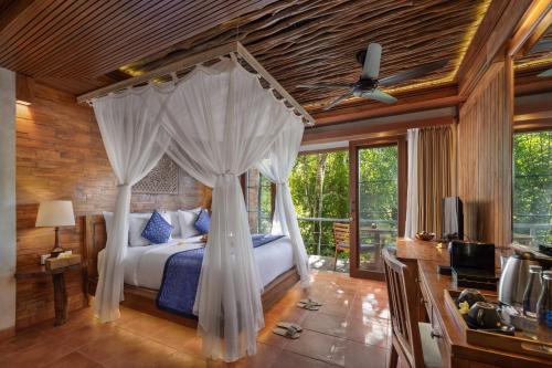 a bedroom with a bed with a canopy at Sacred Valley by GenuineHost in Tegalalang