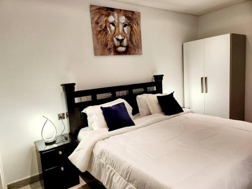 1 dormitorio con 1 cama grande y una pintura del león en la pared en Luxurious & Comfy Gem-5 Star Location-Pools Gym!, en Accra