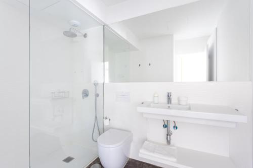 a white bathroom with a toilet and a sink at Home2Book Casablanca Las Teresitas Beach in San Andrés