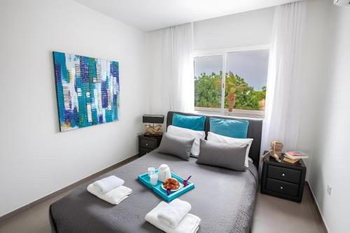 a bedroom with a bed with a tray of food on it at Sun & Sea Seaview Apartment in Protaras