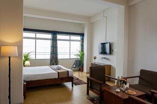 um quarto com uma cama e uma sala de estar em Blissful Stay em Gangtok