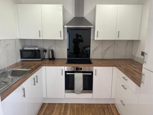 a kitchen with white cabinets and a stove top oven at X1 Humble Abode in Manchester