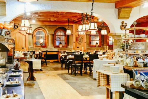 a restaurant with tables and chairs in a room at Atlas Grand Hotel in Garmisch-Partenkirchen