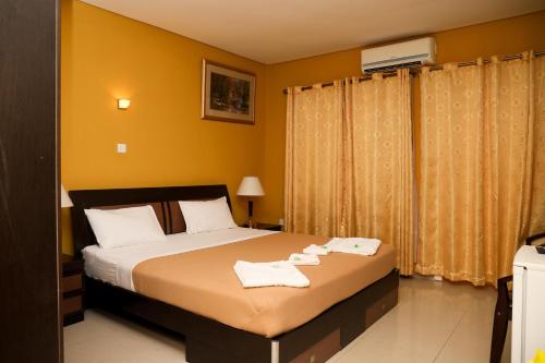 a bedroom with a bed with two towels on it at Mansea Beach Hotel in Kololi