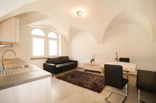 a kitchen and living room with a couch and a table at B&B Zum Guten Tropfen in San Paolo
