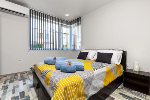 ein Schlafzimmer mit einem Bett mit blauen Kissen darauf in der Unterkunft Florance flat next to Old Town & City Center NEW in Plowdiw