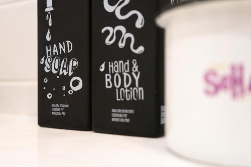 two books with hand soap and a hand and body lotion at Hotel Schani Salon in Vienna
