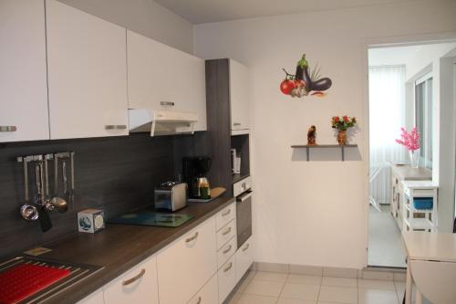 a kitchen with white cabinets and a counter top at Le TOM de ROYAN in Royan