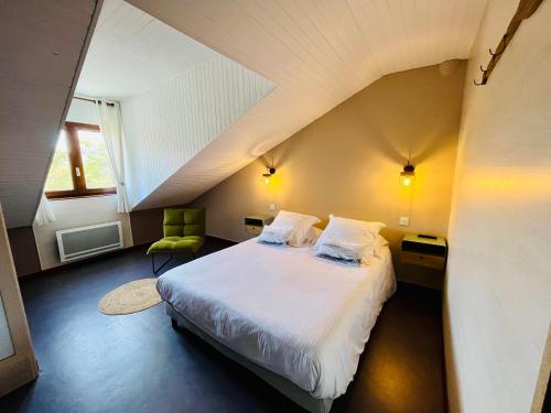 a bedroom with a bed and a green chair at Hôtel les Chaumettes in Savines