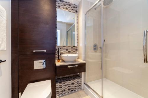 y baño con aseo, lavabo y ducha. en Modern 3BDR Flat w large balcony, Kentish Town en Londres