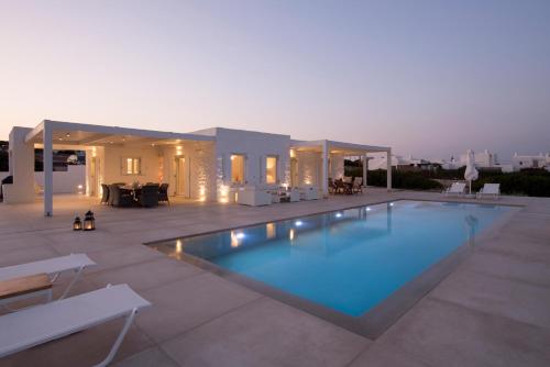 a swimming pool on a patio with a house at White Santa Maria Villa in Santa Maria