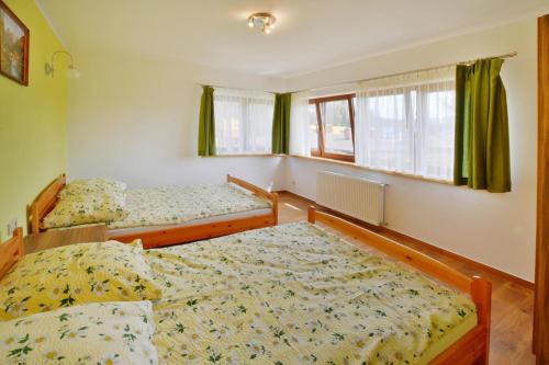 two beds in a room with green curtains at Comfortable holiday home with a nice garden, close to the sea, Sarbinowo in Sarbinowo