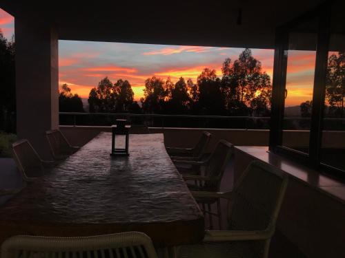 a table and chairs on a balcony with a sunset at Soleada in Gijón
