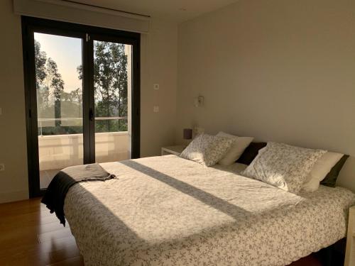 a bedroom with a large bed and a large window at Soleada in Gijón