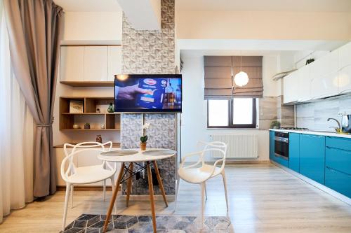 CityLife Apartments في ياش: مطبخ مع دواليب زرقاء وطاولة وكراسي
