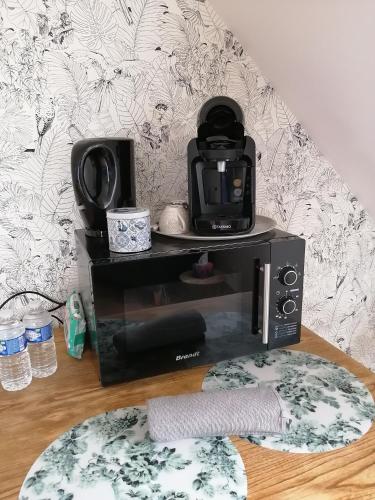 a microwave oven sitting on top of a table at La Chambre du Valois in Cuvergnon