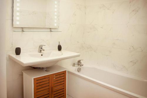 une salle de bain blanche avec un lavabo et une baignoire dans l'établissement Apartment in Macinaggio by the Beach, à Rogliano