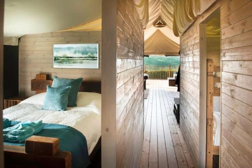 um quarto com uma cama e piso em madeira em Troney Valley Escapes - Hare's Hide em Crediton