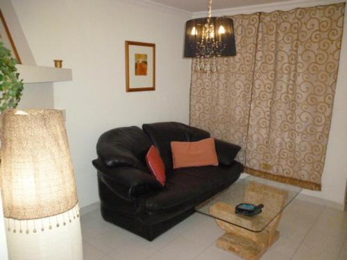 a living room with a black leather couch and a lamp at Apartment Frida in Los Cristianos