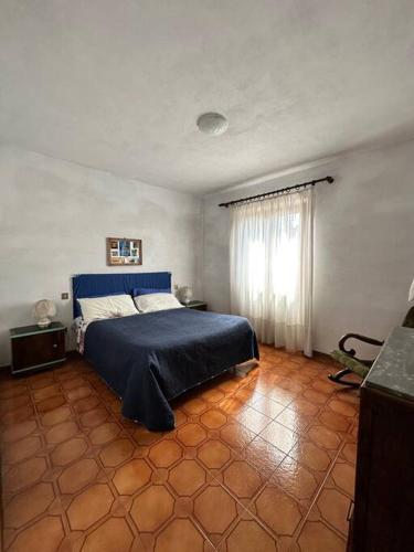 um quarto com uma cama com um cobertor azul em Appartamento Albatros em Ribolla