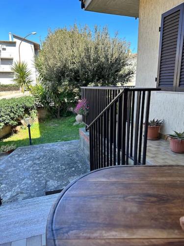 a porch with a wooden table and a fence at Appartamento Albatros in Ribolla