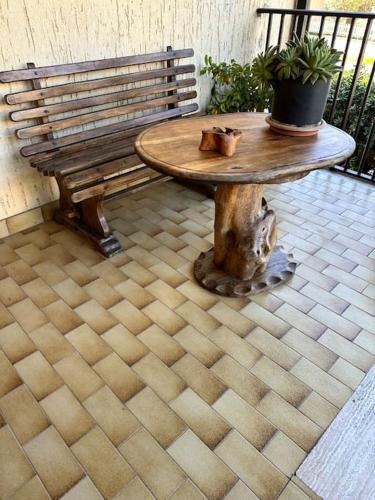 a wooden table and a bench on a patio at Appartamento Albatros in Ribolla