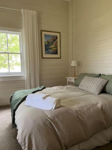 a bedroom with a large bed with towels on it at Primrose Cottage in Mandurama