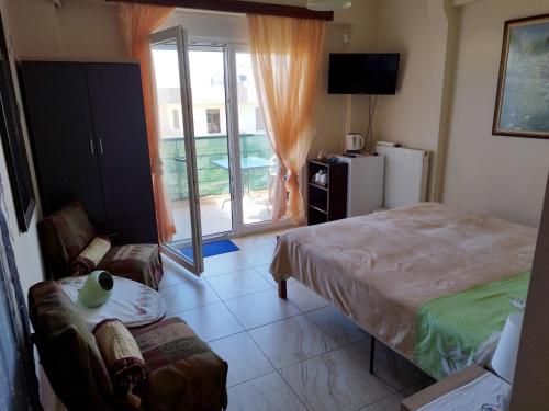 a bedroom with a bed and a living room with a balcony at Mom's Cozy Corner in Heraklio Town