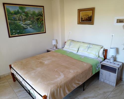 a bedroom with a bed and a painting on the wall at Mom's Cozy Corner in Heraklio