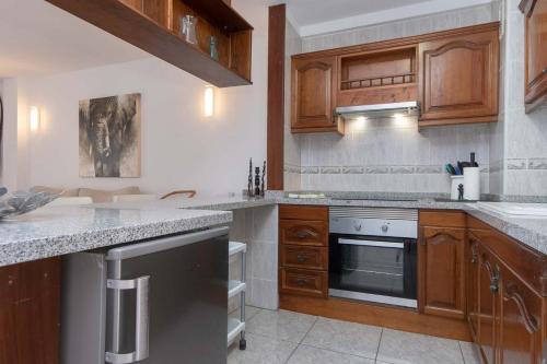 a kitchen with wooden cabinets and stainless steel appliances at Beach View in Los Cristianos