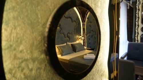 a mirror reflecting a bedroom with a bed in a room at Egoist luxury Hotel in Baku