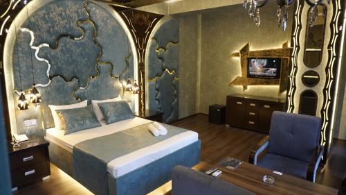 a bedroom with a bed and a desk and a chair at Egoist luxury Hotel in Baku