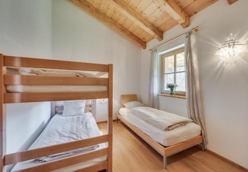 a bedroom with two bunk beds and a window at Chaletdorf am Sonnenhang in Neukirchen am Großvenediger