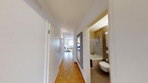 uma casa de banho branca com um WC e um lavatório em Unique Serviced Living @ Airport Line Colmarer em Basileia