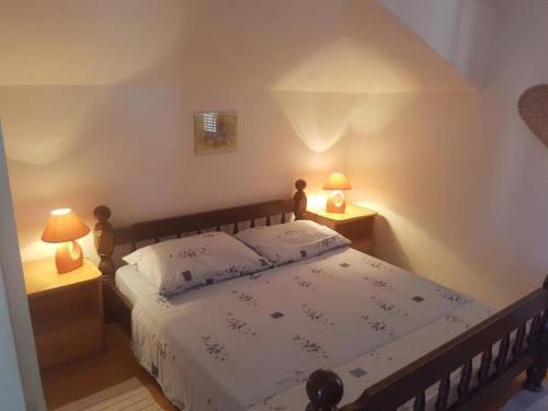 a bedroom with a bed with two lamps on tables at Apartment in Slatine with sea view, terrace, air conditioning, WiFi 5147-1 in Slatine